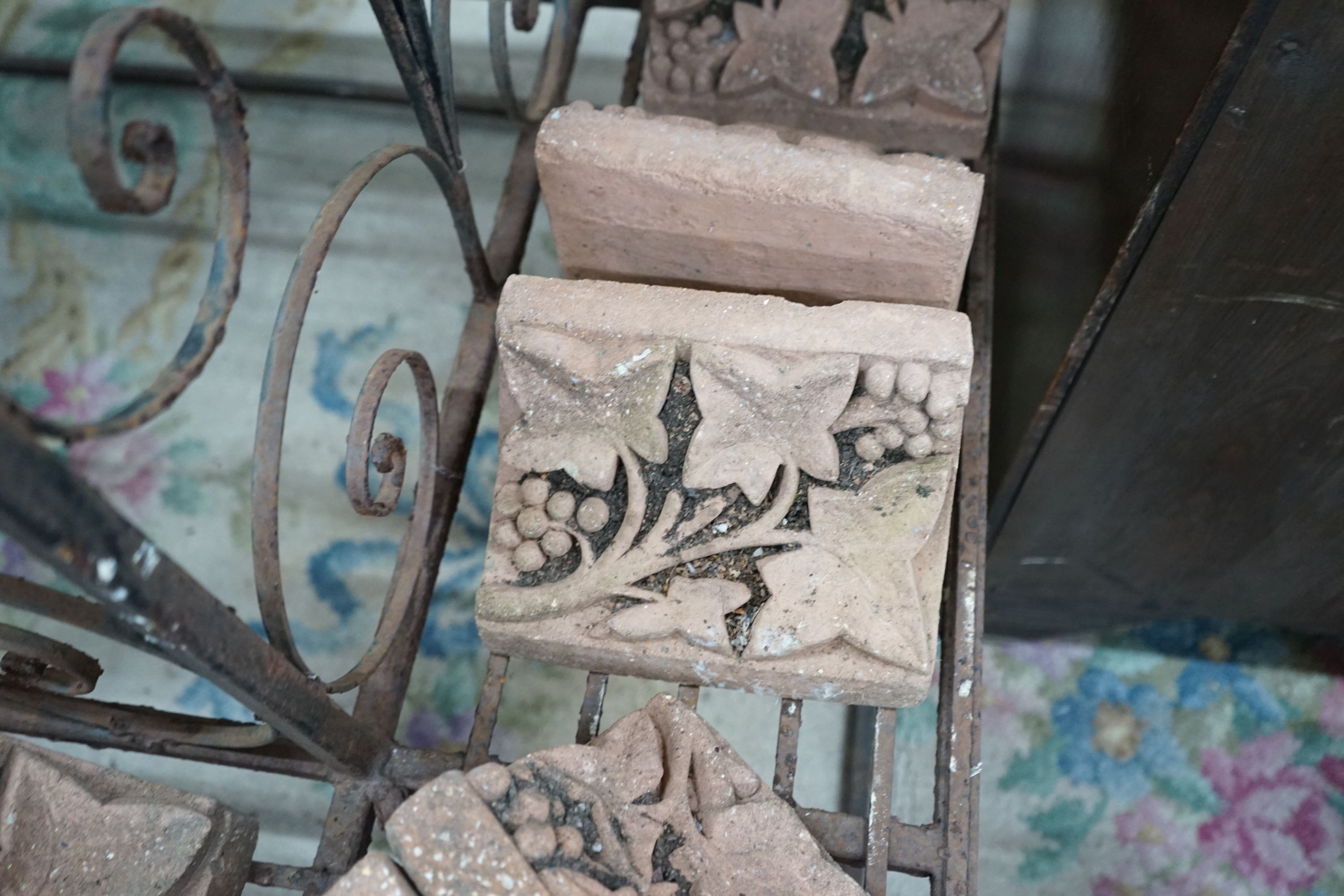 Fourteen terracotta edging tiles moulded with fruiting vines, each width 23cm, depth 14cm, height 15cm